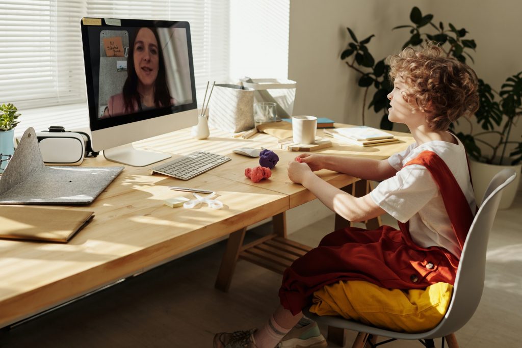Menina no escritório assistindo suas aulas remotas