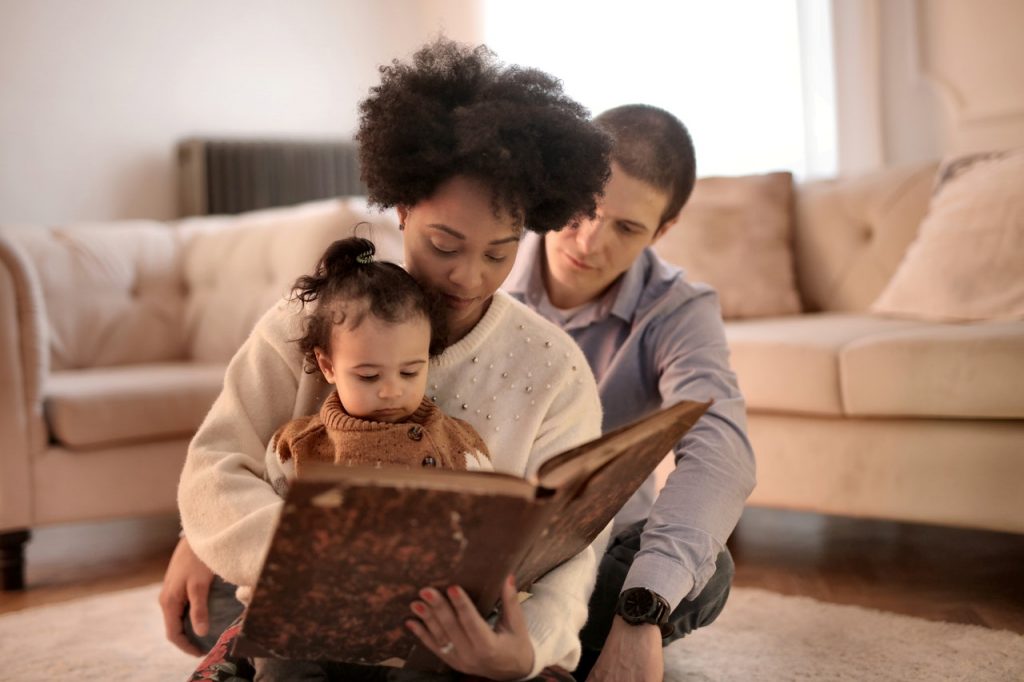 5 atividades para aproximar pais e filhos Uma família compartilha uma leitura como uma forma de atividades para aproximar pais e filhos em casa