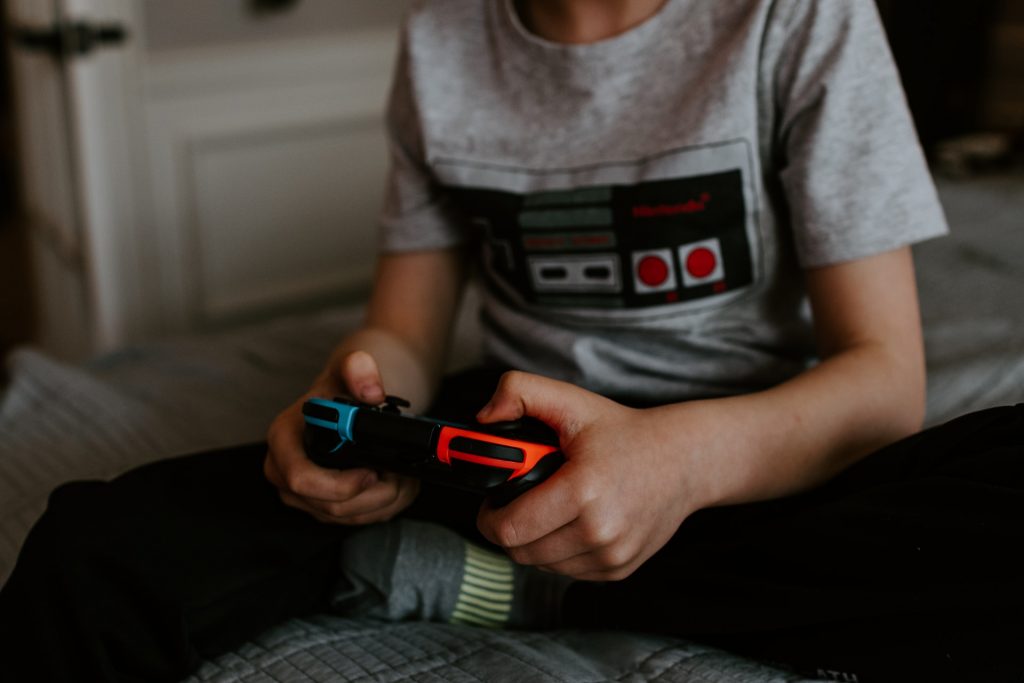 Jogos para aprender inglês: conheça alguns exemplos Uma criança joga em um videogame um dos jogos para aprender inglês