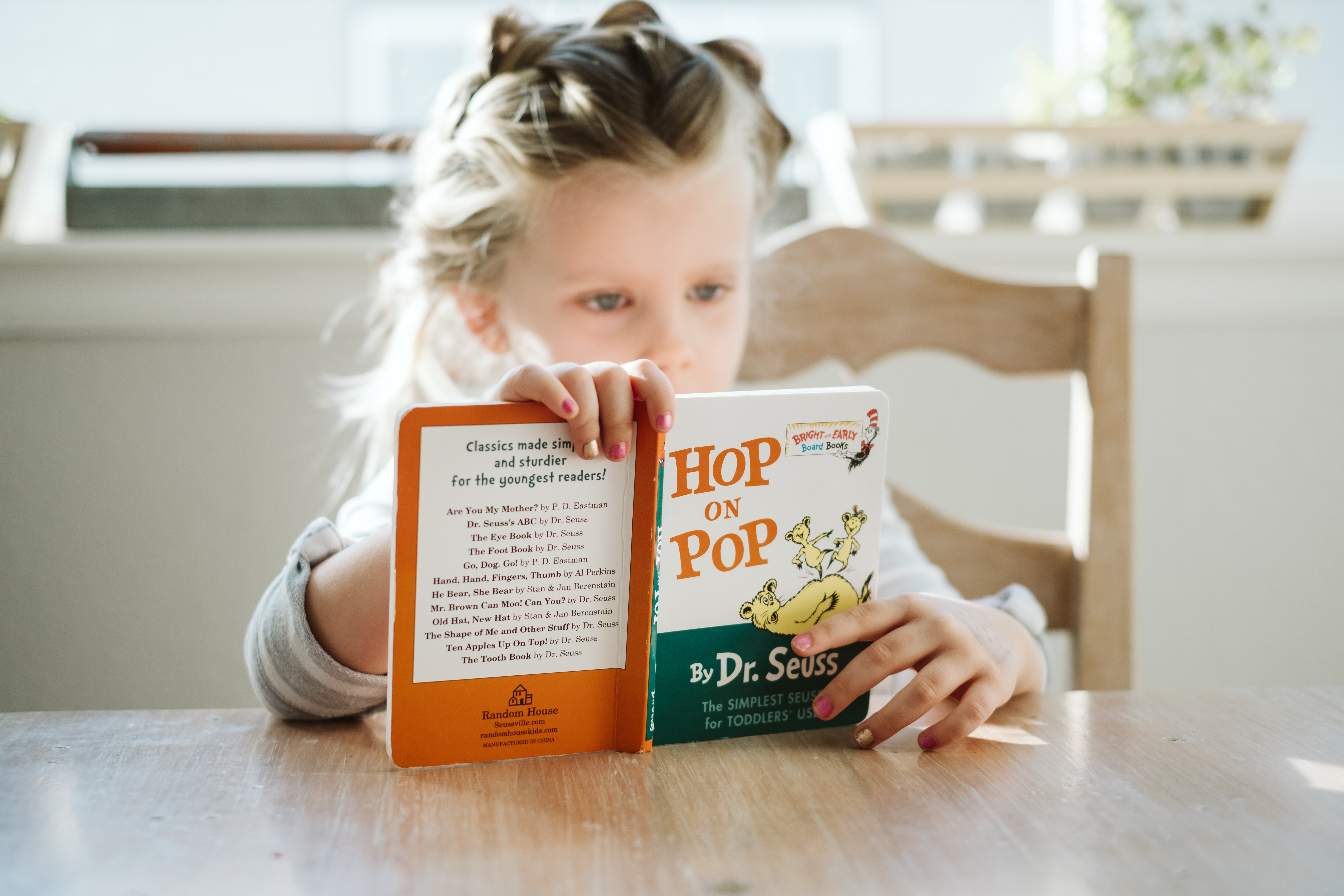 A importância do inglês: imagem de criança lendo livro em inglês