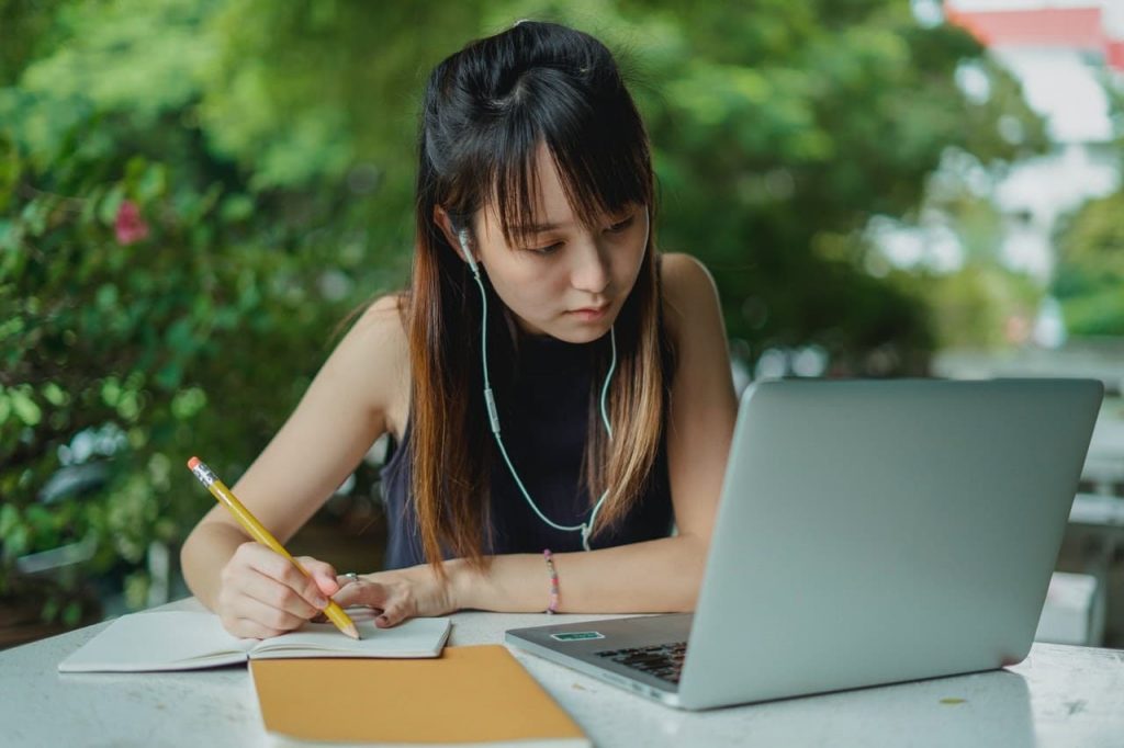 Atente-se às expressões e gírias menina estudando inglês vendo série.