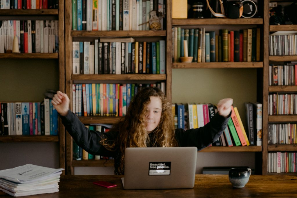 Como as músicas em inglês podem ajudar no aprendizado? Uma estudante está se divertindo escutando musicas em inglês.
