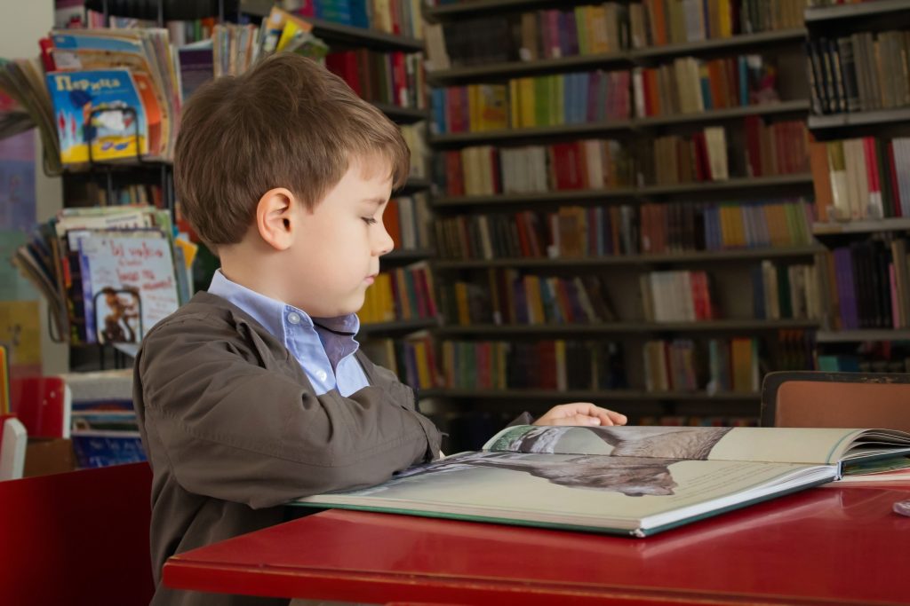 Garoto lendo em uma biblioteca