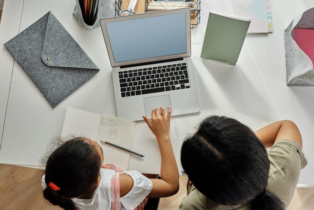 Na imagem, uma aluna tira dúvidas com sua professora em seu computador após aprender em sua rotina de estudos.
