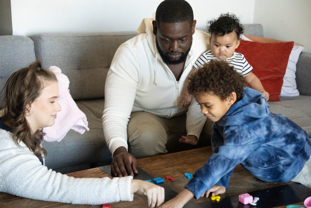 Uma família está brincando com letras e figuras para expressar seus sentimentos em inglês.