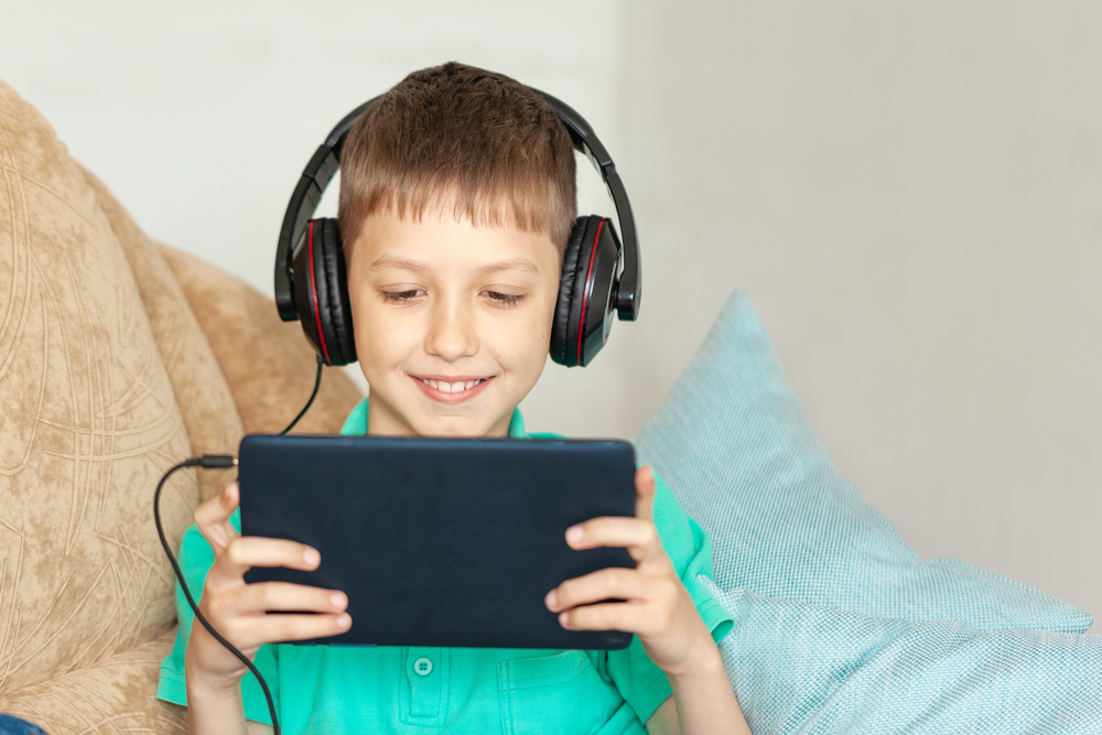 Criança assistindo a um podcast em tablet