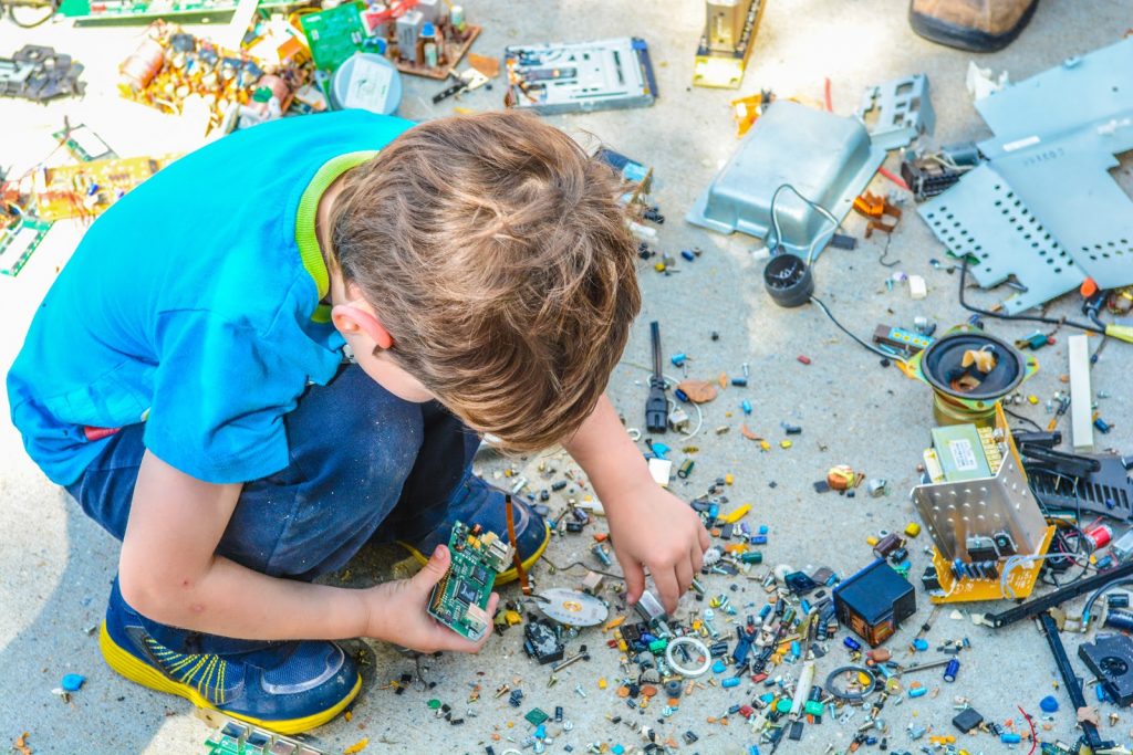 Criança brincando com pecinhas de hardware, demonstrando o que é DIY.